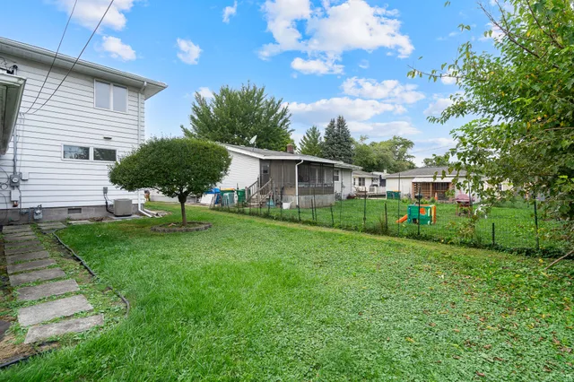 a backyard of a house with table and chairs