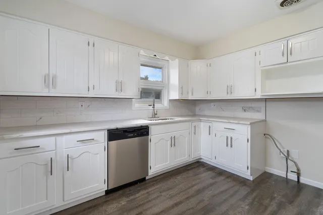 a kitchen with granite countertop white cabinets and white appliances