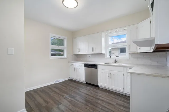 a kitchen with granite countertop white cabinets and white appliances