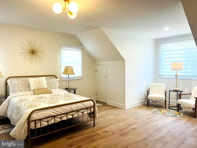 a bedroom with a bed a table and painting on the wall