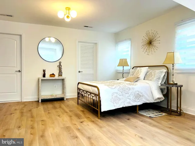 a bedroom with a bed mirror and a window