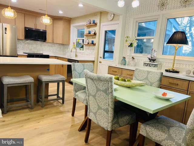 a living room with stainless steel appliances kitchen island granite countertop furniture and a fireplace