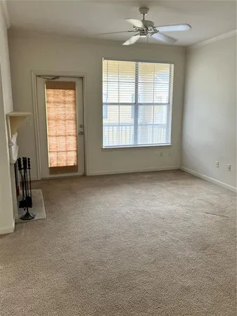 an empty room with windows and fan