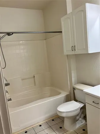 a white toilet sitting next to a bath tub