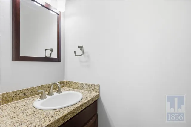 a bathroom with a granite countertop sink and a mirror