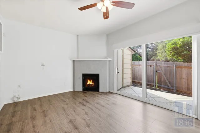 a view of an empty room with a fireplace and a window