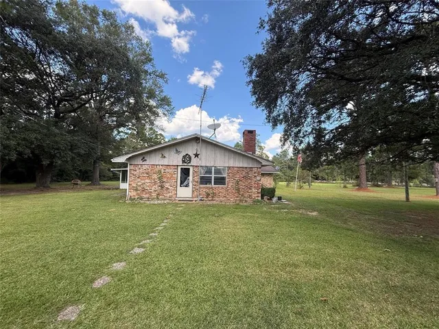 a view of a house with a yard and sitting area