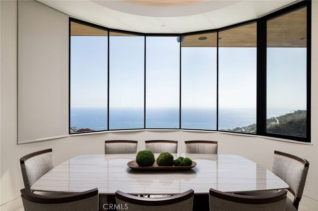a living room with furniture a large window and kitchen view