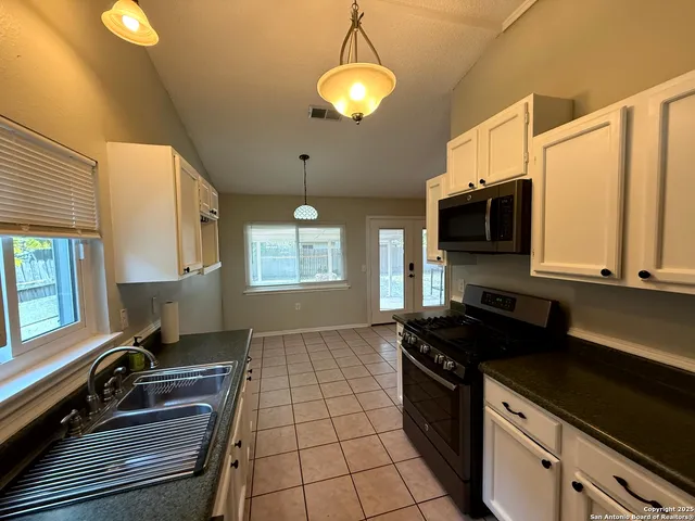 a kitchen with a sink stove and microwave