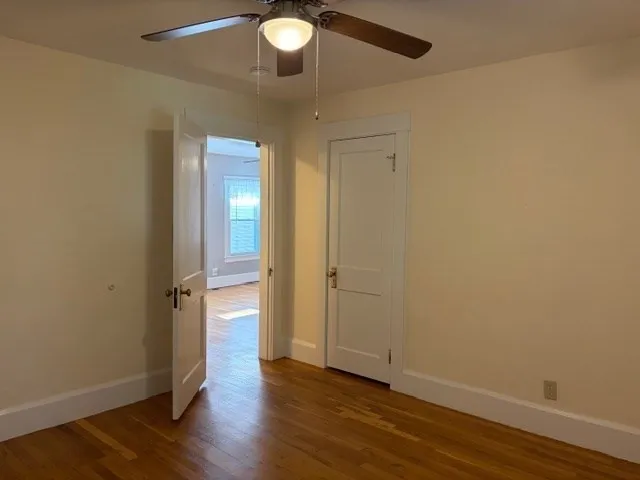 an empty room with a window and a ceiling fan