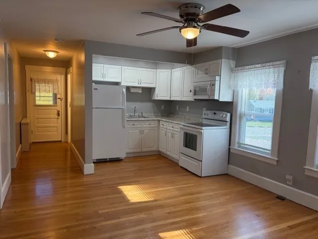 a kitchen with a refrigerator a sink and dishwasher a oven with wooden floor
