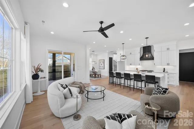 a living room with furniture kitchen view and a large window