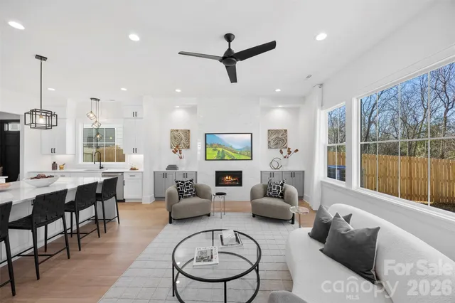 a living room with furniture kitchen view and a large window