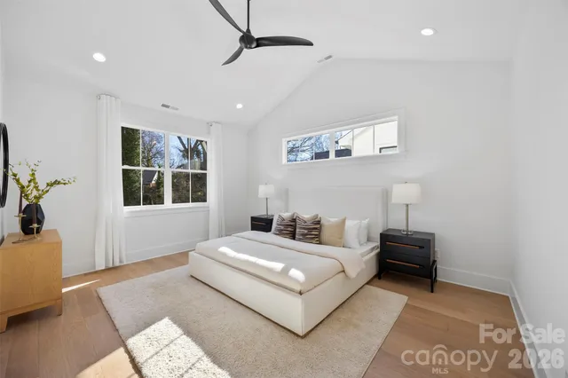 a bedroom with a bed wooden floor and window