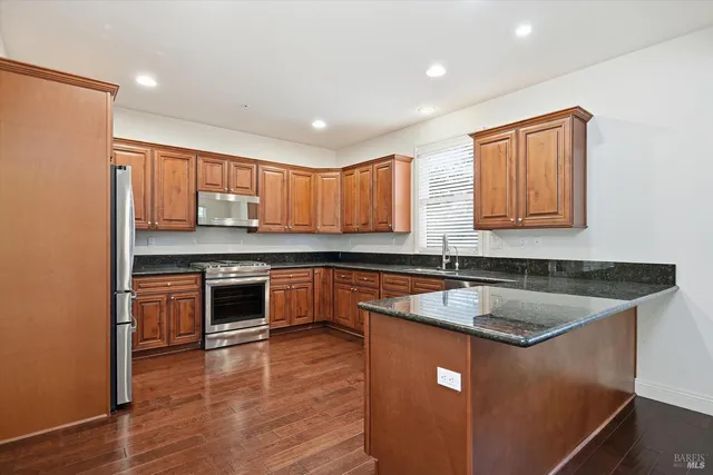 a kitchen with stainless steel appliances granite countertop a sink stove and refrigerator