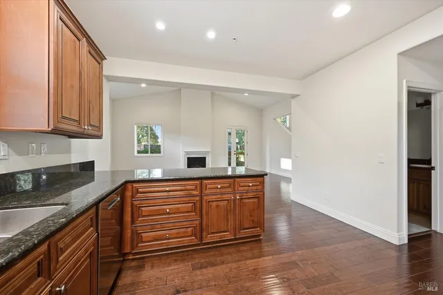 a kitchen with stainless steel appliances granite countertop a sink and wooden cabinets