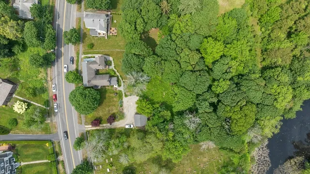 an aerial view of residential house with outdoor space and trees all around
