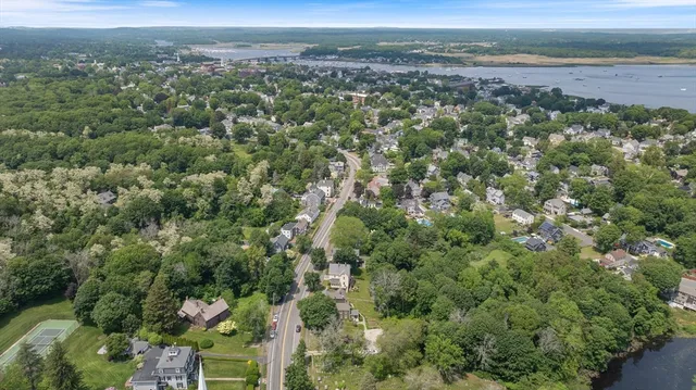 an aerial view of a houses with a lush green hillside