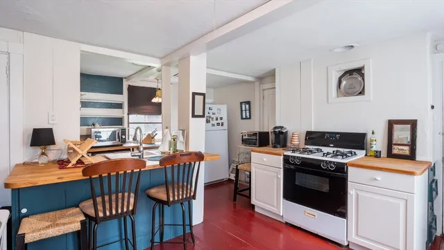 a kitchen that has a stove a table and chairs in it