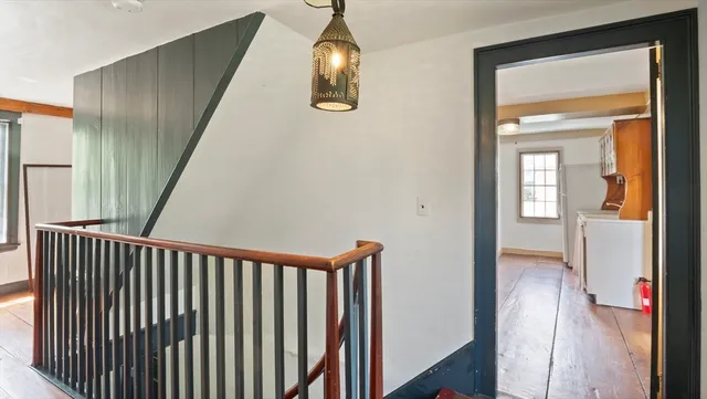 a view of a hallway with wooden floor and stairs