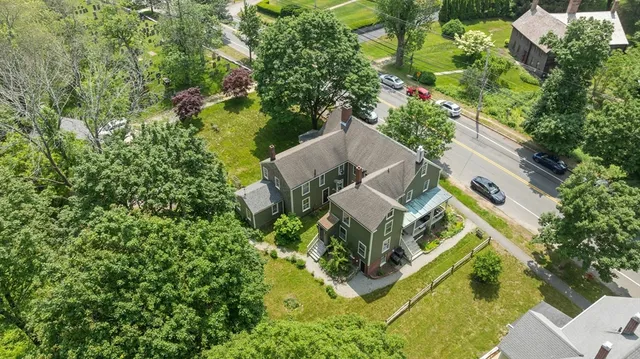 an aerial view of a house with garden space and trees all around