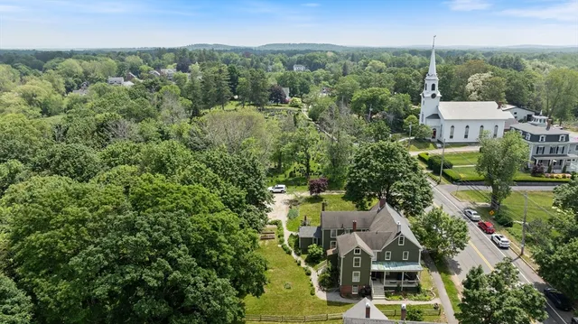 an aerial view of residential houses with outdoor space and trees