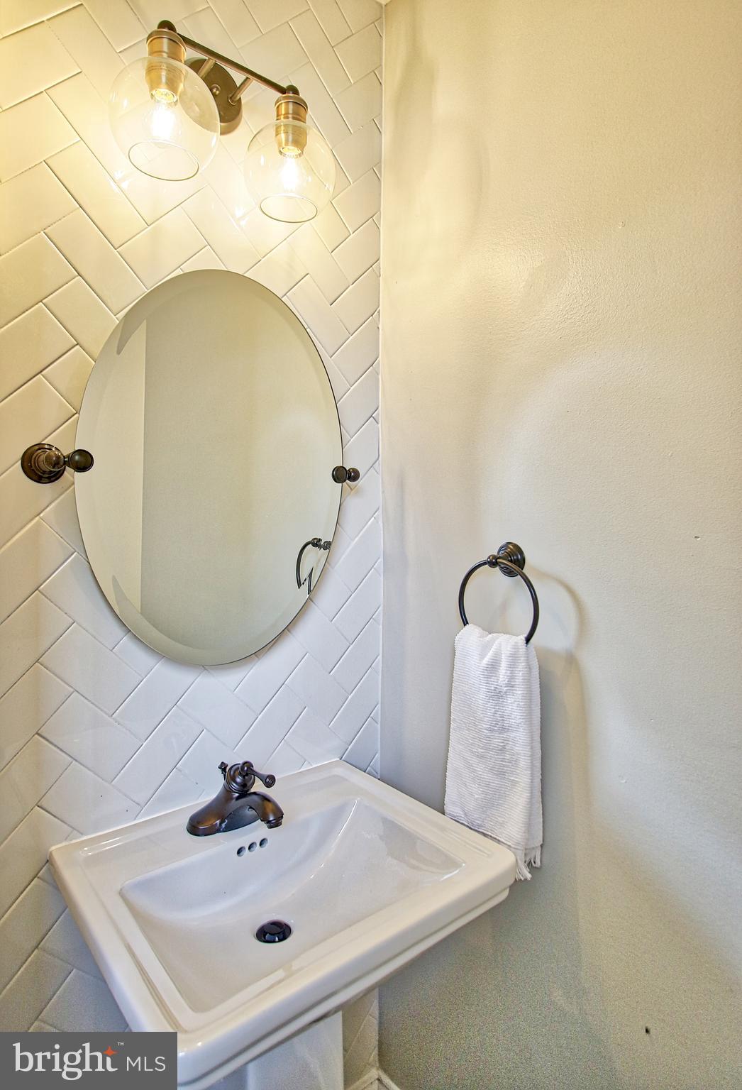 301 West Cold Spring Lane Baltimore, MD 21210 - Photo 18 of 38 a bathroom with a sink and mirror