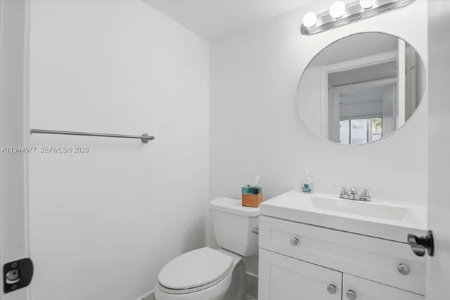 a bathroom with a sink mirror vanity and toilet