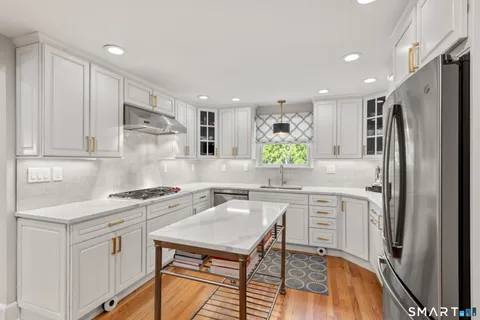 a kitchen with white cabinets and refrigerator