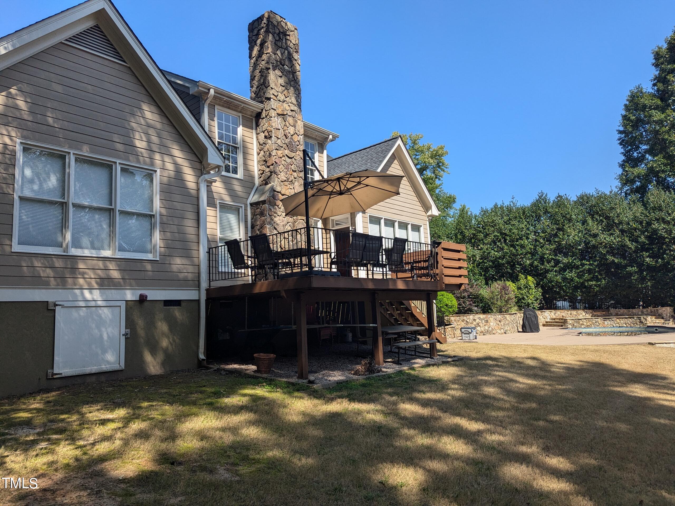 151 Michael Way Clayton, NC 27520 - Photo 16 of 36 a view of a house with a wooden deck and a floor to ceiling window