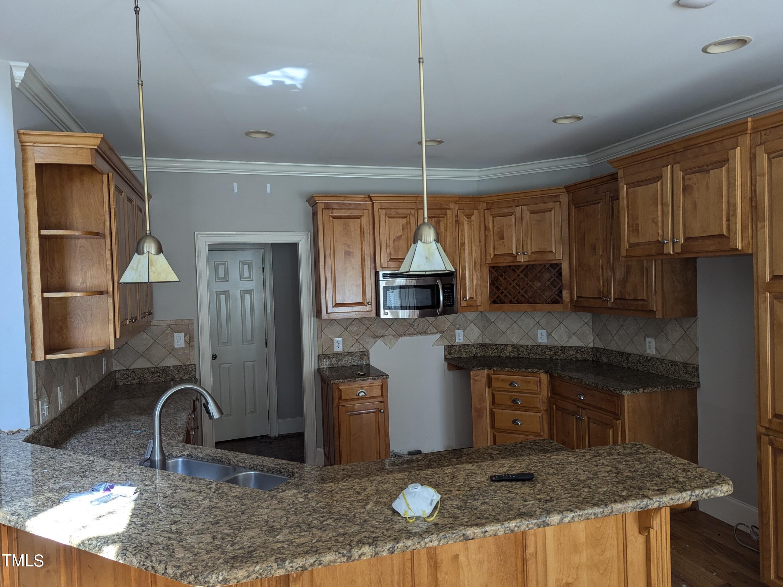 151 Michael Way Clayton, NC 27520 - Photo 10 of 36 a kitchen with granite countertop a sink a counter space appliances and cabinets