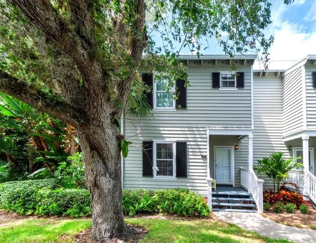 a view of house that has a tree in front of the house