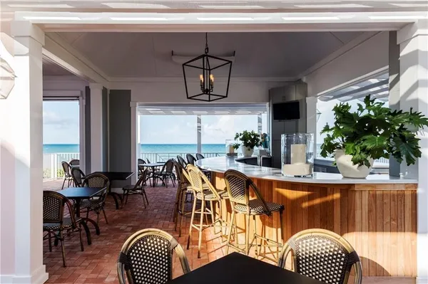 a dining room with furniture potted plants and wooden floor