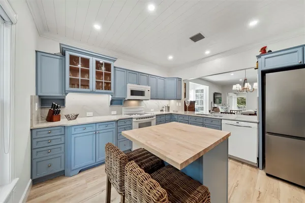a kitchen with stainless steel appliances kitchen island granite countertop a refrigerator and a stove top oven