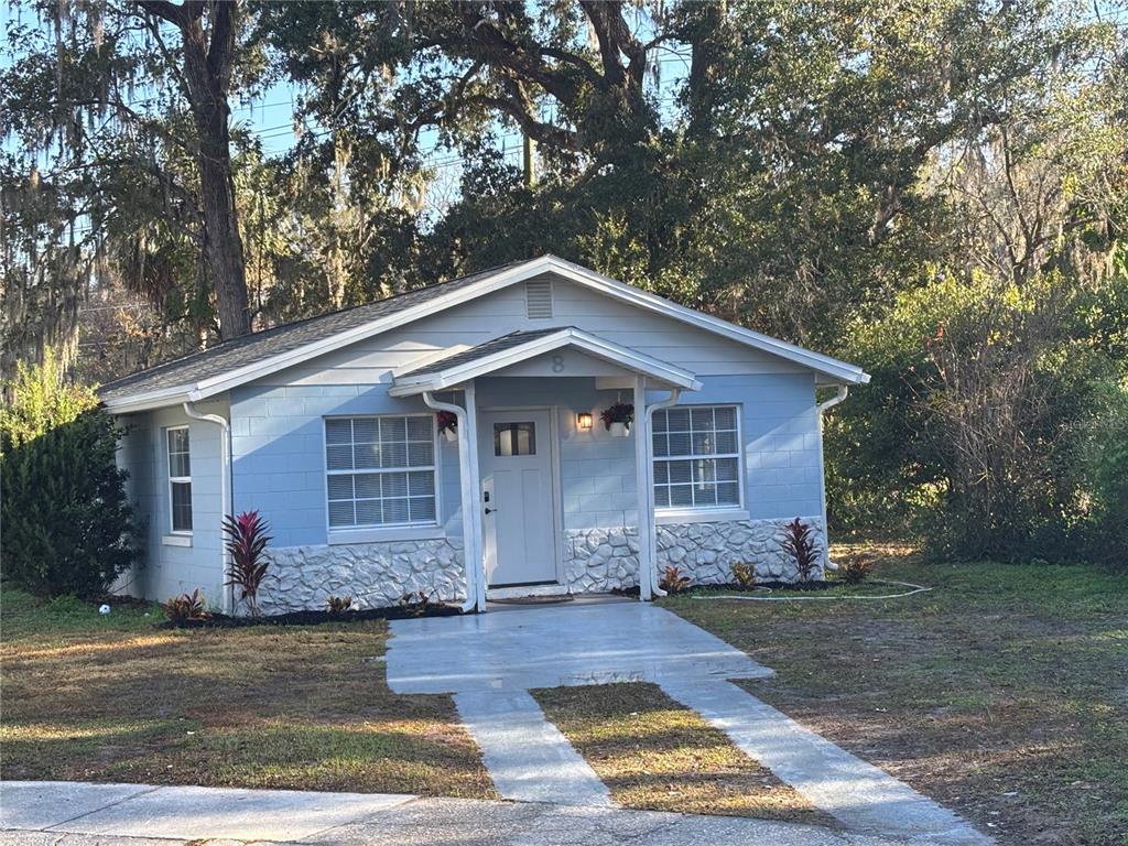 a front view of house with yard and trees in the background
