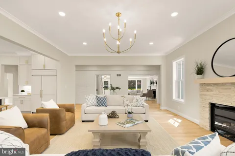 a living room with furniture a fireplace and a chandelier