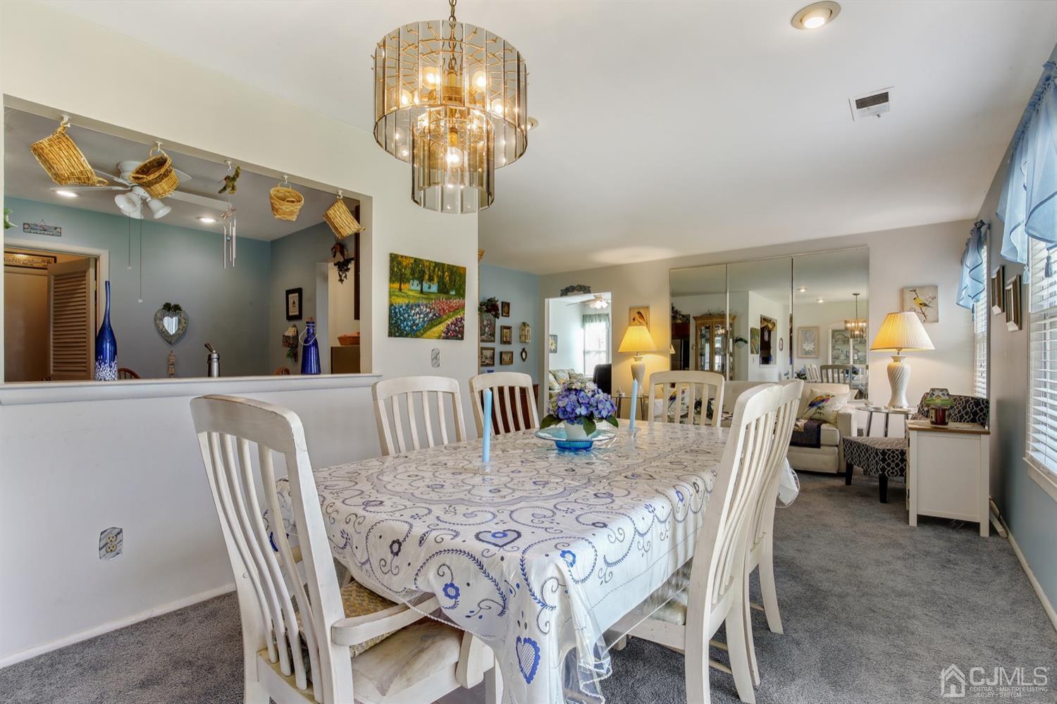 149 Woodbury Road Edison, NJ 08820 - Photo 5 of 19 a view of a dining room with furniture a chandelier and wooden floor