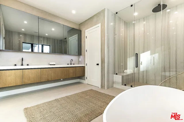 a bathroom with a tub a sink and mirrors