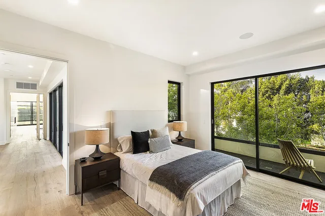 a bedroom with a bed and large window