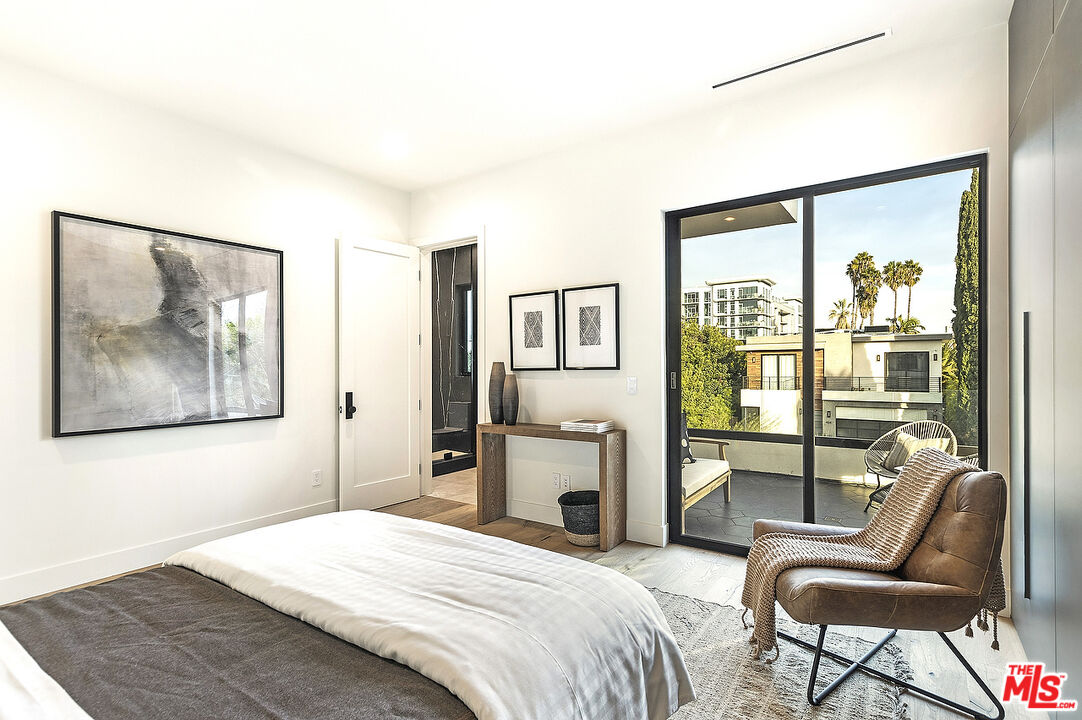 8566 Colgate Avenue Los Angeles, CA 90048 - Photo 17 of 22 a bedroom with a bed and glass windows