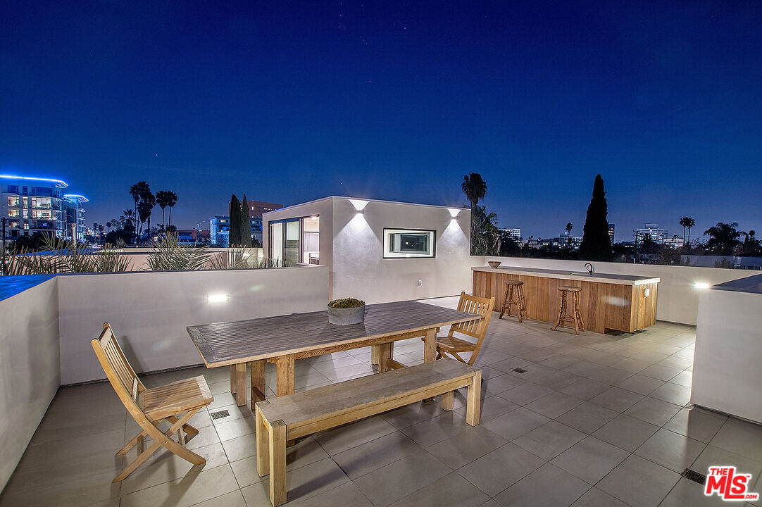 8566 Colgate Avenue Los Angeles, CA 90048 - Photo 22 of 22 a kitchen with a table chairs a stove and a dining table with wooden floor