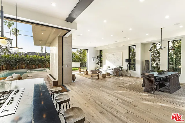 a living room with furniture floor to ceiling window and wooden floor