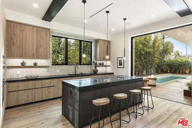 a kitchen with stainless steel appliances granite countertop a stove a sink and a wooden cabinets