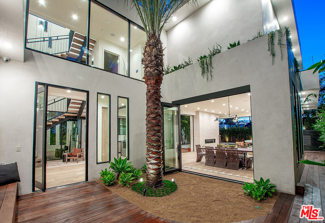 8566 Colgate Avenue Los Angeles, CA 90048 - Photo 10 of 22 a porch with potted plants and floor to ceiling window