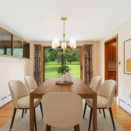 a dining room with furniture a chandelier and wooden floor