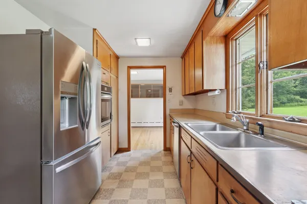 a kitchen with a refrigerator sink and cabinets