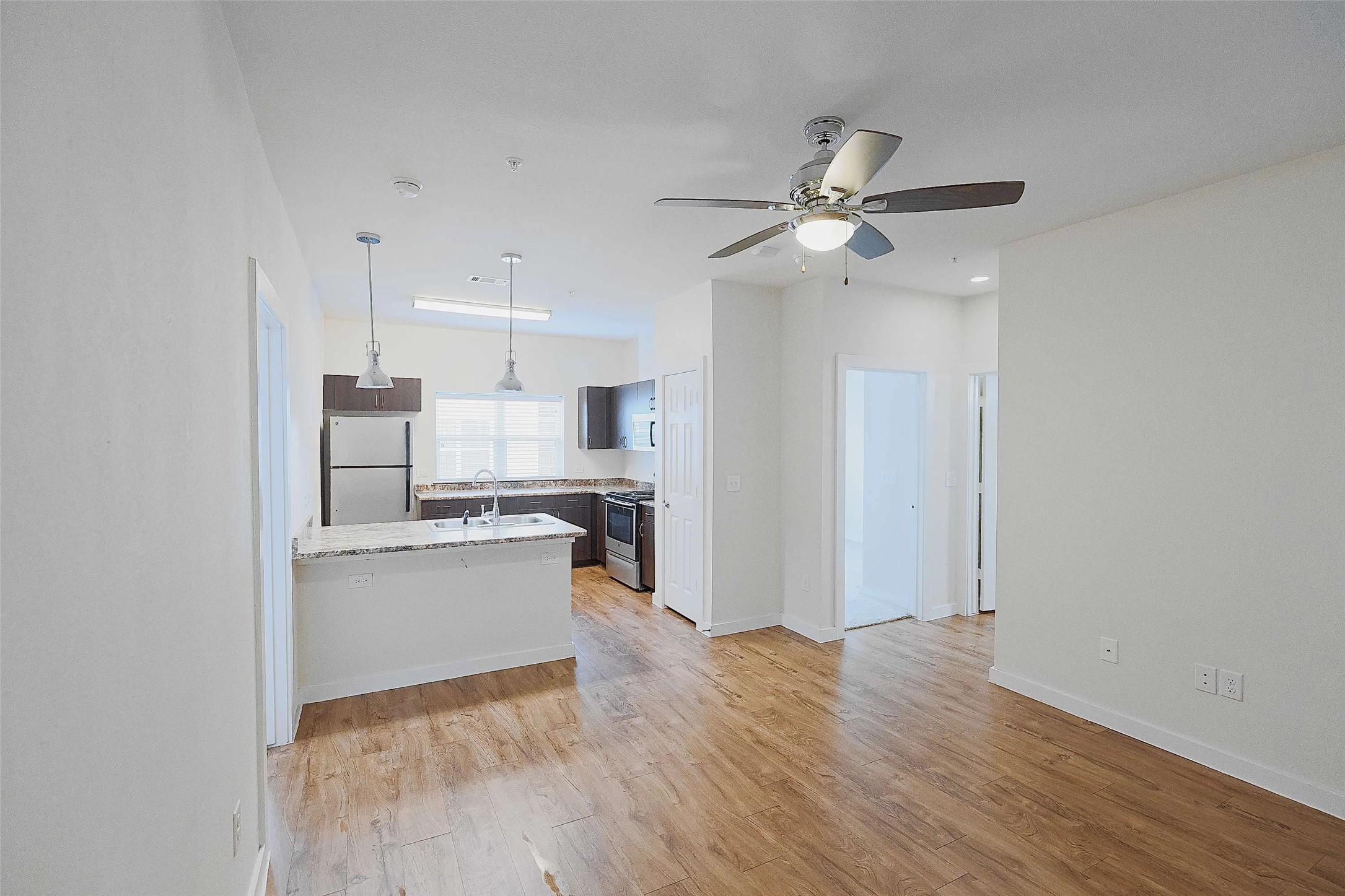 6725 Circle S Road, Unit C1125 Austin, TX 78745 - Photo 11 of 13 a kitchen with a refrigerator a sink and dishwasher a stove with wooden floor