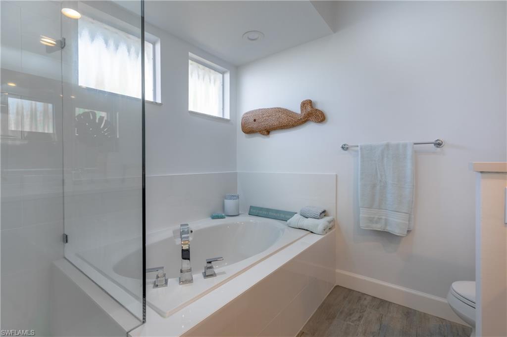 790 Willowbrook Drive, Unit 305 Naples, FL 34108 - Photo 11 of 23 a bathroom with a tub and a shower
