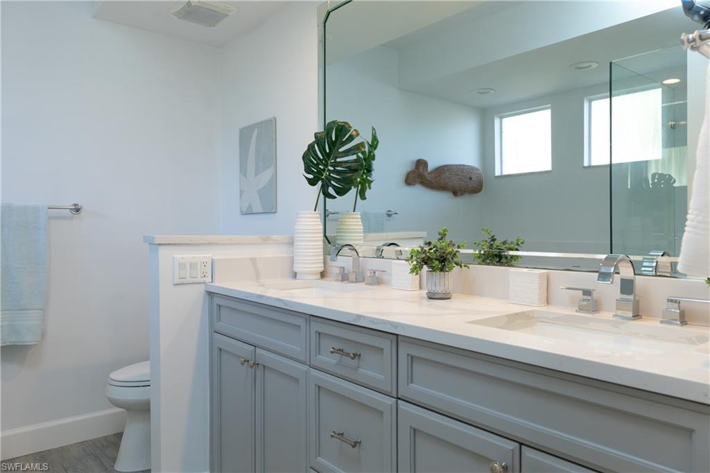 790 Willowbrook Drive, Unit 305 Naples, FL 34108 - Photo 12 of 23 a bathroom with a granite countertop toilet sink and mirror