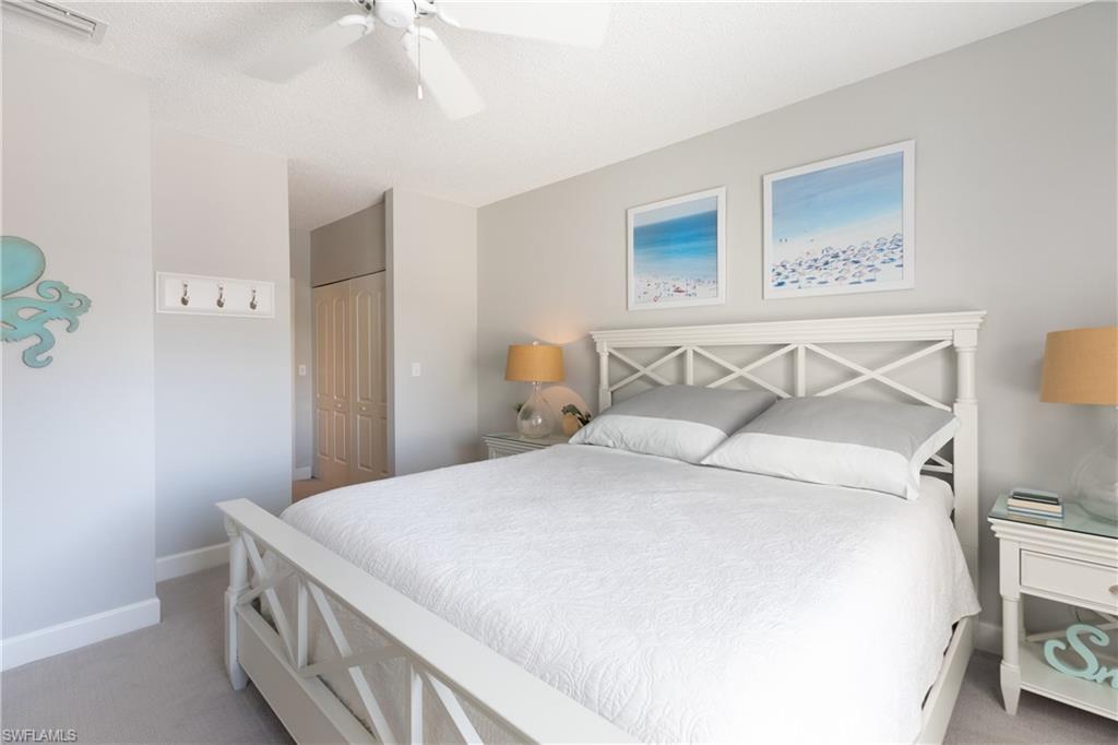 790 Willowbrook Drive, Unit 305 Naples, FL 34108 - Photo 16 of 23 a bedroom with a bed and a night stand